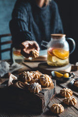 A woman reaches for a cake and drinks grapefruit tea. Healthy drink.