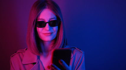 Footage of beautiful surprised Caucasian young woman with open mouth wearing black sunglasses reading message in neon lights. Big blue eyes. Good news. Bob hairstyle.