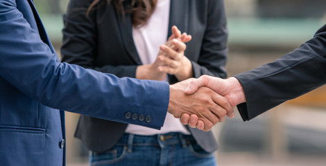 Handshaking, business people congratulations shaking hands and applaud together.