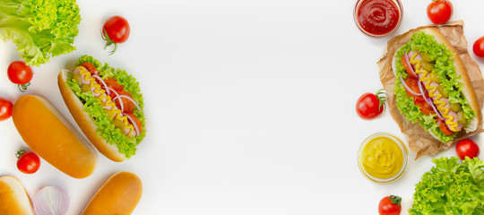 Hot dog with pickles, tomatoes and lettuce on a white background. Fast food. Calorie food. View from above. Space for copy. Food banner.