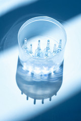 medicines ampoules on a white background with container in blur on behind