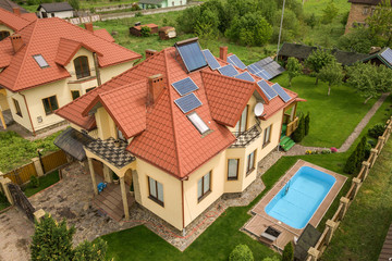 Aerial view of a new autonomous house with solar panels and water heating radiators on the roof and...