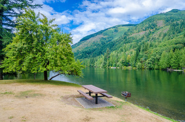 Fototapeta premium Picnic tables near mountain lake in Vancouver, Canada.