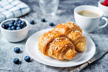 Fresh croissants with berries and cup of coffee