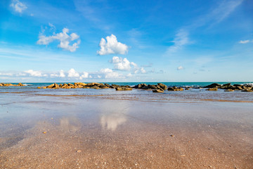 Sandy beach with seashells on sea island at high tide	