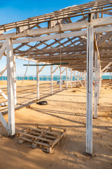 Fototapeta na wymiar Unfinished wooden structure for sunshade. Wooden awning structure for resting on the seashore in the off-season