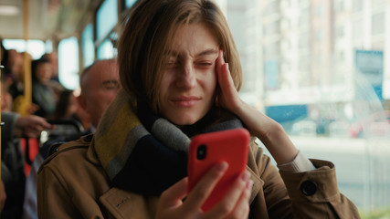 Woman use phone coughs into handkerchief sneezes on the tram look at camera cold autumn day flu season disease fever grippe health illness infection influenza migraine sickness slow motion