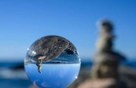 Orb on beach with stacked rocks - Powered by Adobe