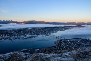 A beautiful cityscape of Tromso (including the Artic Cathedral) partly covered by cloud taken from Fløya during sunset