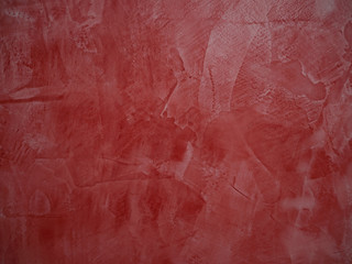 Red painted grunge wall with bumps and scratches, modern interior decoration abstract background.