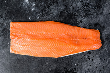 Raw salmon fillet. Organic fish. Black background. Top view