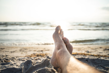 Relaxing in the sunset, feet on the beach