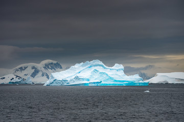 blue curved iceberg in water in Antarctica
