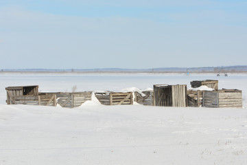 Fototapeta na wymiar Vegetable crates on frozen agricultural field