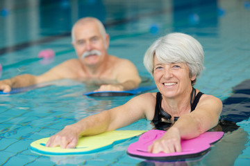 portrait of senior man and woman in swimming pool