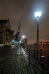 A view along the dockside at night at The Royal Victoria Docks in London, England