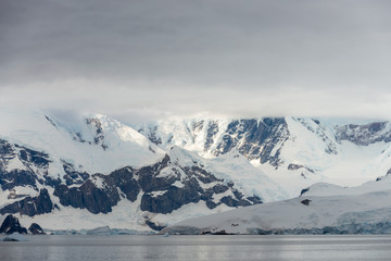 Antarctic beach with glacier and mountains, view from expedition ship
