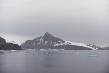 Antarctic beach with glacier and mountains, view from expedition ship