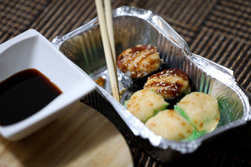 Take away sushi set on a brown background.
