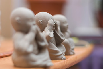 Priests meditation; buddhist monks closeup of toy figures I saw nothing, I heard nothing, I said...