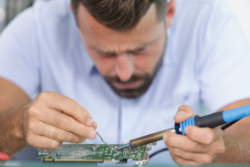 technician repairing a computer mainboard