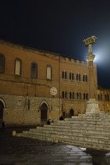 Fototapeta premium Piazza del Duomo. Illuminated Capitoline wolf statue symbol of the city with a view of the side Duomo steps. Siena by night.