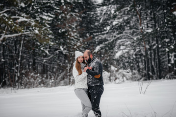 Fototapeta na wymiar Couple playing with snow in the forest