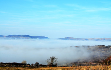 landscape with fog between hills