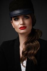 Beautiful sexy woman in a fashionable hat, with classic make-up, wave hair and red lips. Beauty face.