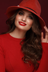 Beautiful sexy woman in a fashionable hat, with classic make-up, wave hair and red lips. Beauty face.