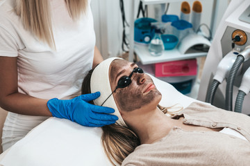 Beautiful woman getting carbon face peeling procedure in a beauty salon.
