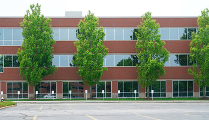 facade view of office building with green trees in front