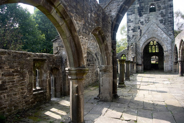 Obraz premium The ruined church of Saint Thomas a Beckett, in the Yorkshire village of Heptonstall. A beautiful small place set above a valley in the foothills of the Pennine mountain range. Columns and shadows.