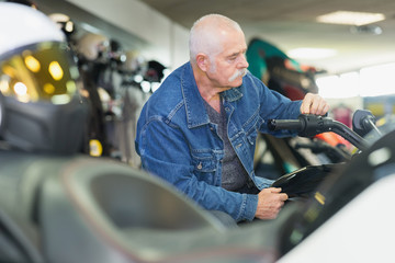 senior man in motorcycle store
