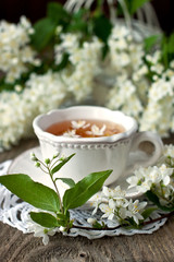 Jasmine flowers  and cup of tea on rustic background
