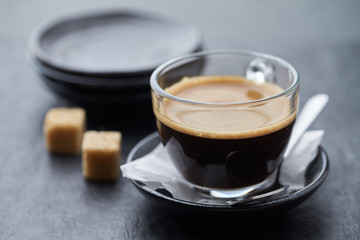 Coffee in glass cup on dark stone background. Close up.