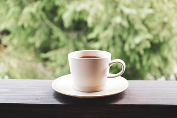 A cup of tea on the railing of the terrace, close-up. Morning concept. 