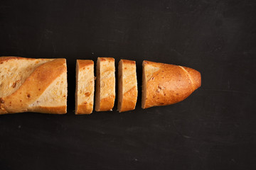 one sliced french baguettes lie on an old wooden table with free space for text