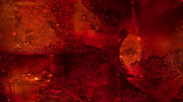 Cola is pouring and foaming slow motion in glass on black background closeup macro shot 4K