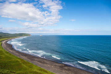 Wild beach made of volcanic sand on the Pacific Ocean, Kamchatka Peninsula, Russia.