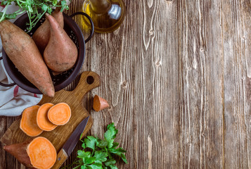 Organic farm sweet potato on rustic wooden background. Healthy eating and zero waste concept. Top...