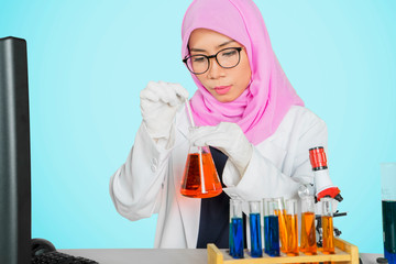 Female researcher pouring chemical liquid on tube