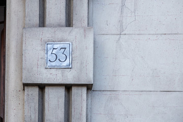 number 53, ancient house number plate on brick wall, Italy