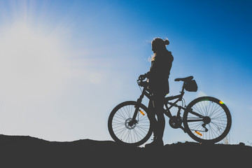 Obraz na płótnie Canvas silhouette of a sports girl who goes by bicycle