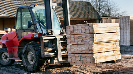 The loader picks up and stacks the lumber