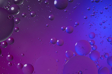Oil drops on water surface color abstract background. blue and pink circles