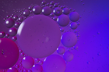 Oil drops on water surface color abstract background. blue and pink circles
