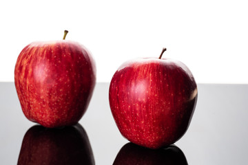 Fresh red apples placed on reflective surface