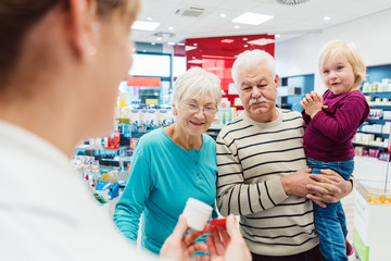 Grandparents in pharmacy buying prescription drugs for grandchild