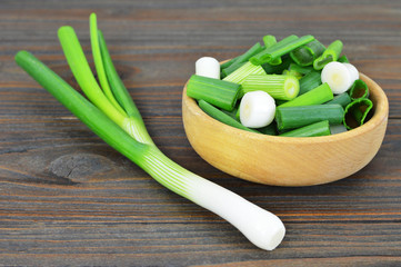 Green onions on wooden background